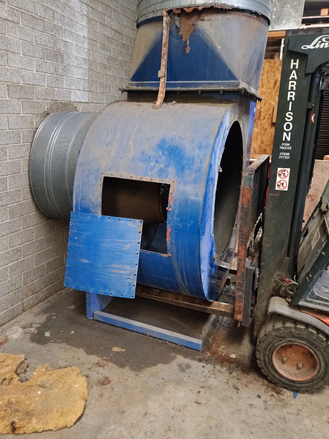 Blue hot air mover with extensive rust damage around its upper duct transition