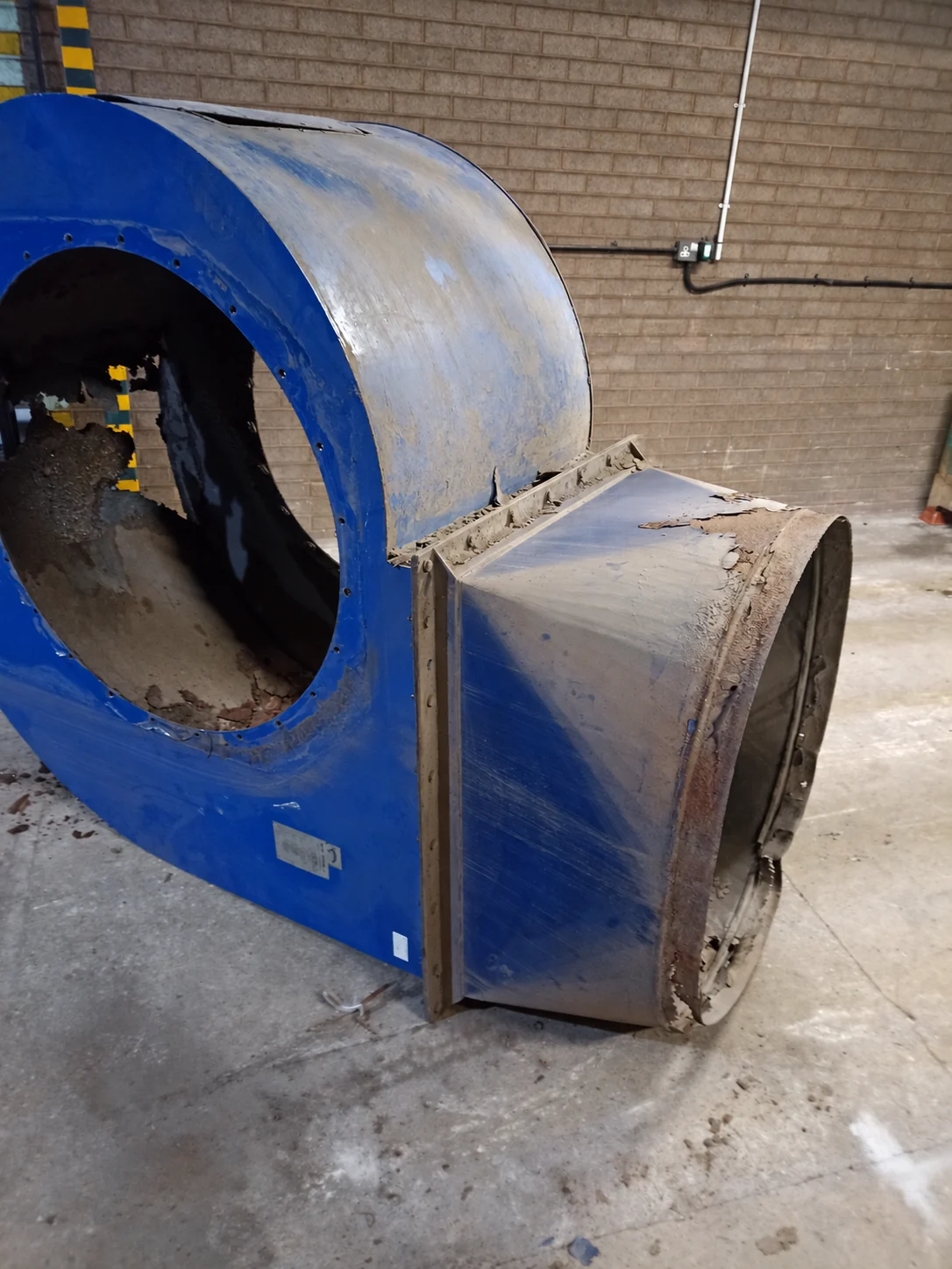 Removed blue fan casing and detached transition showing corroded steelwork