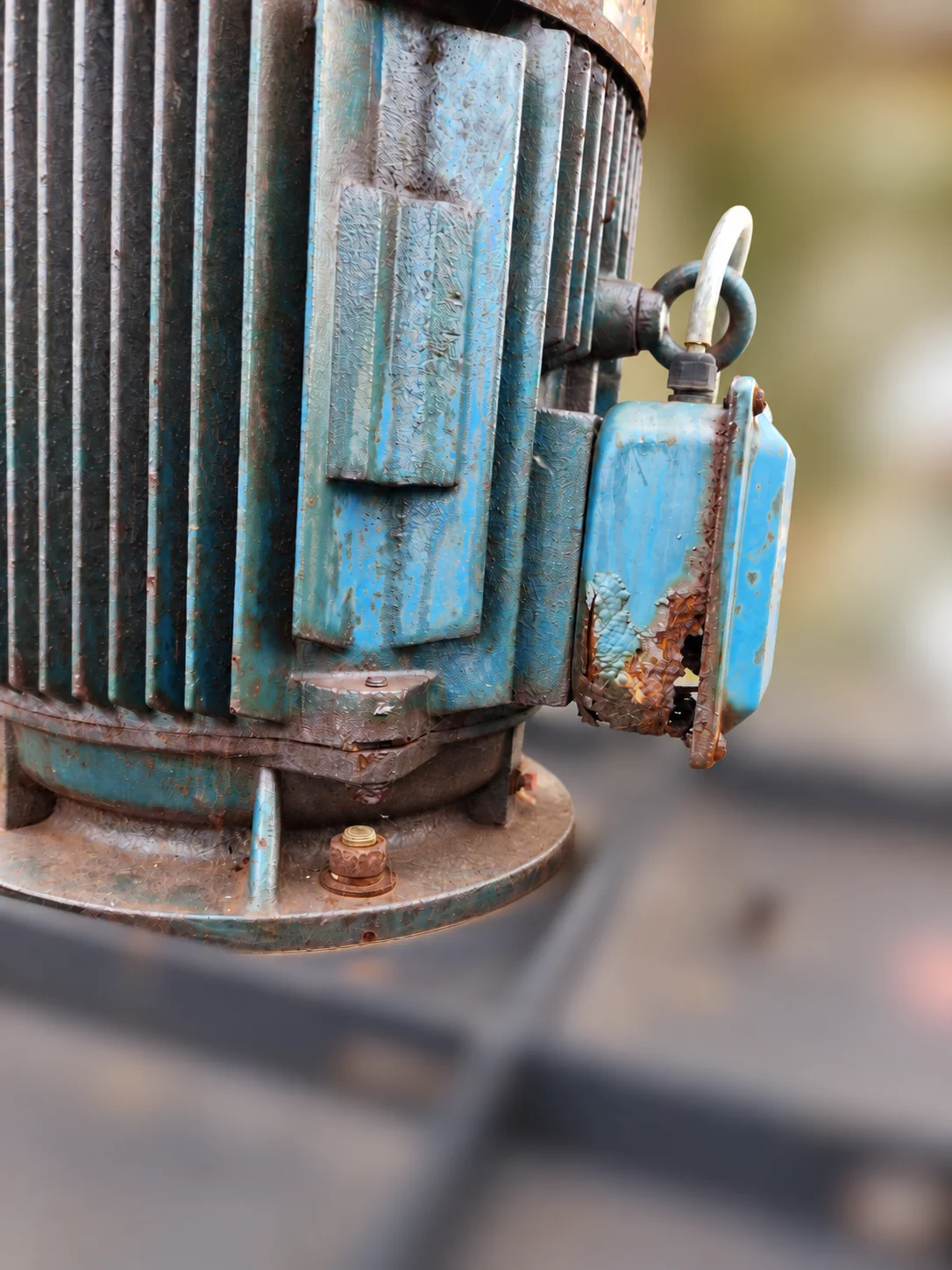 Old motor terminal box with heavily corroded edges and a visible hole