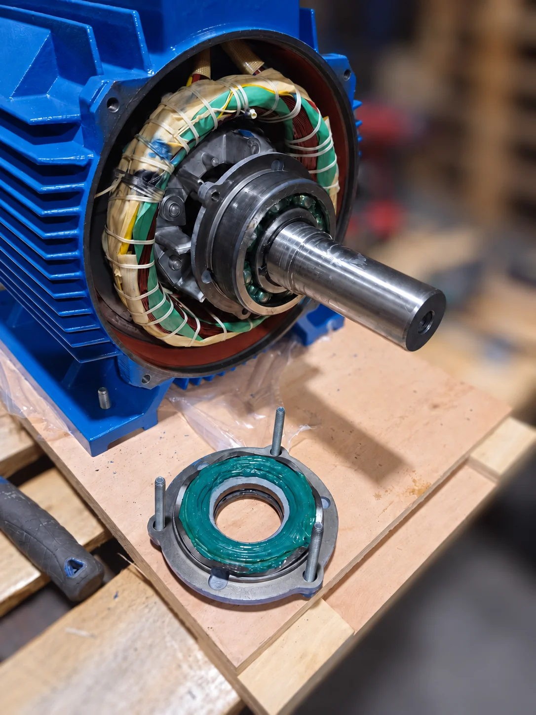 Replacement motor on the workshop bench with its shaft, bearing and removed end cover visible